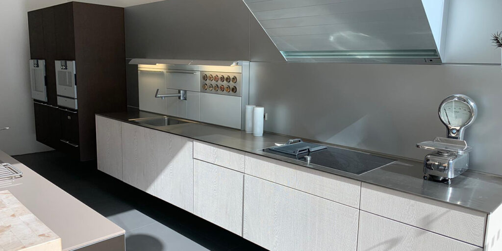 Cuisine bulthaup b3 chêne clair et plan de travail inox avec hotte intégrée, le niveau de finition qui explique le prix d'une cuisine bulthaup